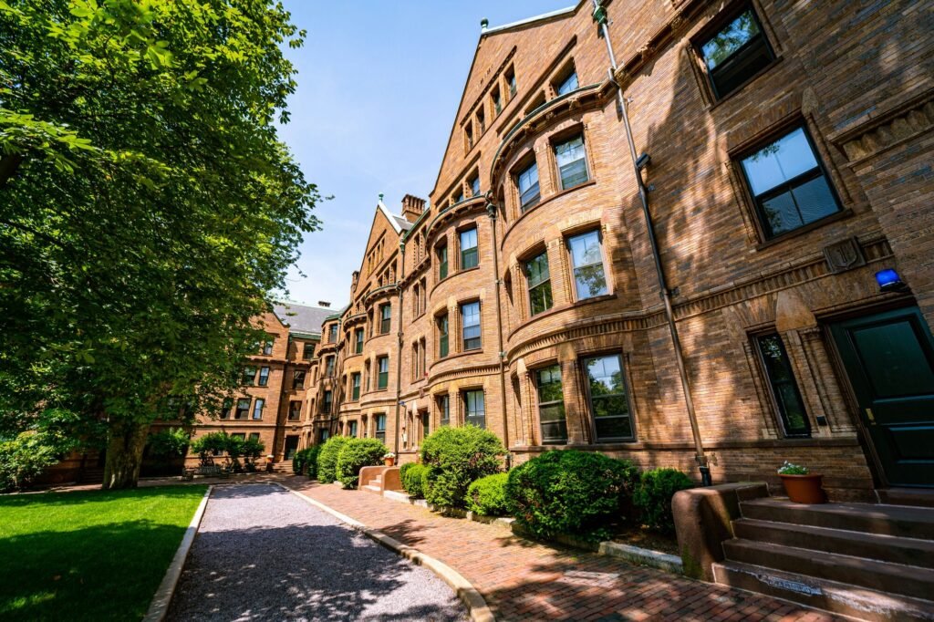 Brick residence halls and a garden path at Harvard on a sunny day